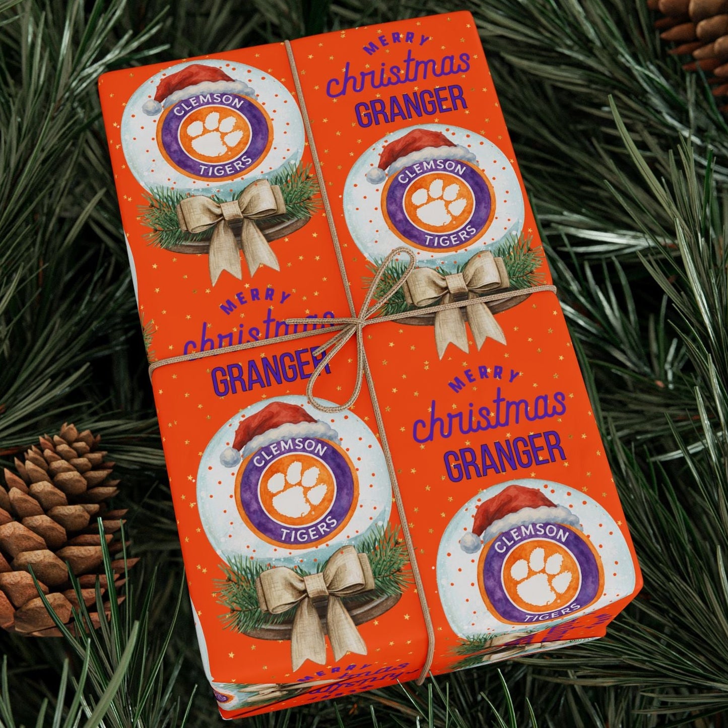 Two orange boxes of Clemson Tigers Christmas Granger on a green leafy background with pine cones.